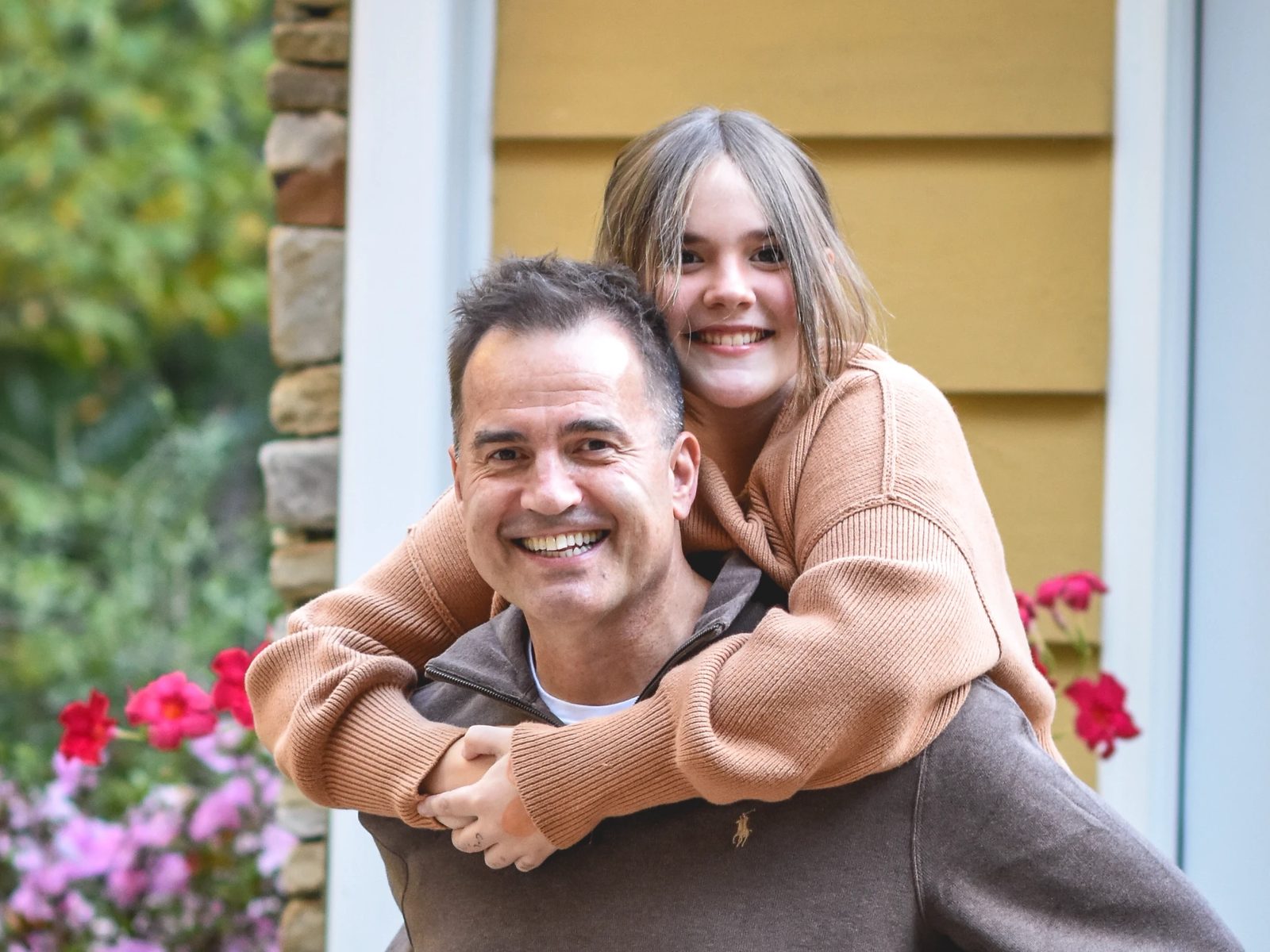 Athena riding piggyback on Chris, both grinning