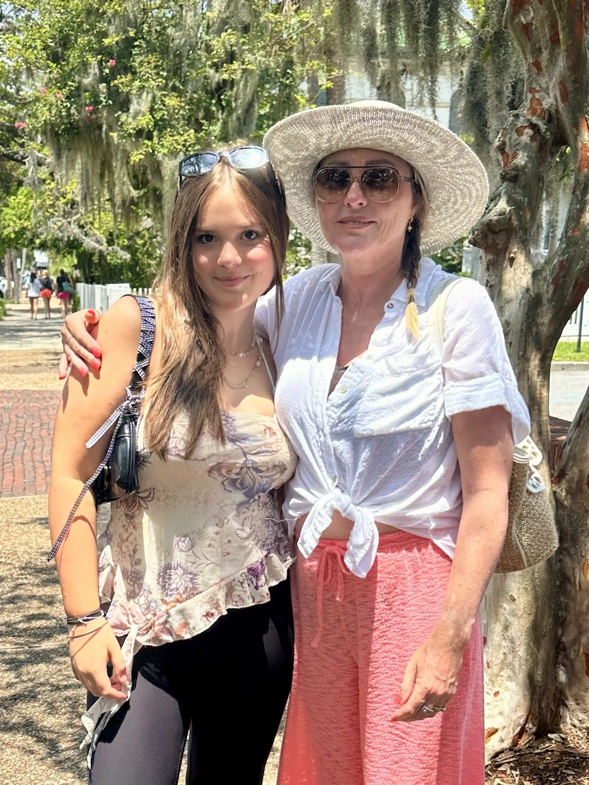 Joanne with her arm around Athena under live oaks